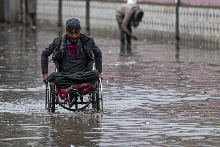 Man in a wheelchair going through flood waters